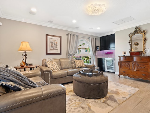 living room featuring wine cooler, indoor bar, ornamental molding, and light wood-type flooring