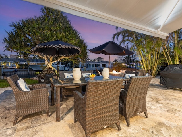 patio terrace at dusk featuring grilling area