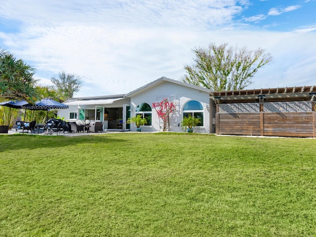 rear view of property with a patio and a lawn