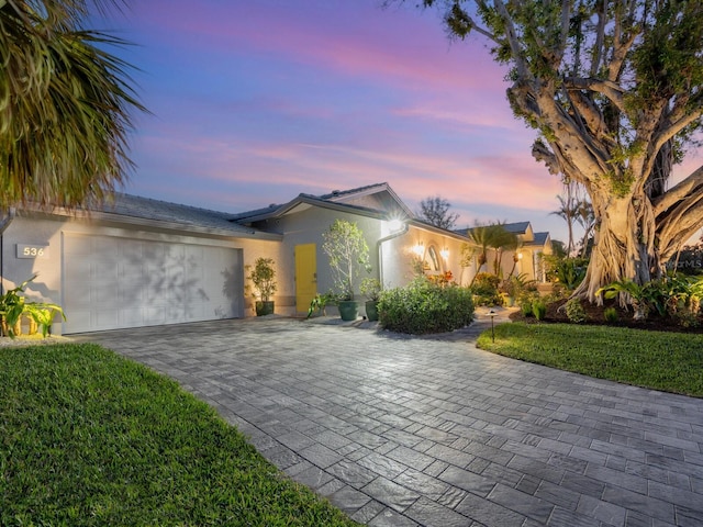 view of front of property featuring a garage and a lawn