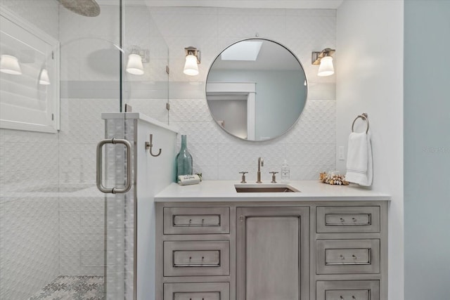 bathroom featuring decorative backsplash, vanity, and a shower with shower door