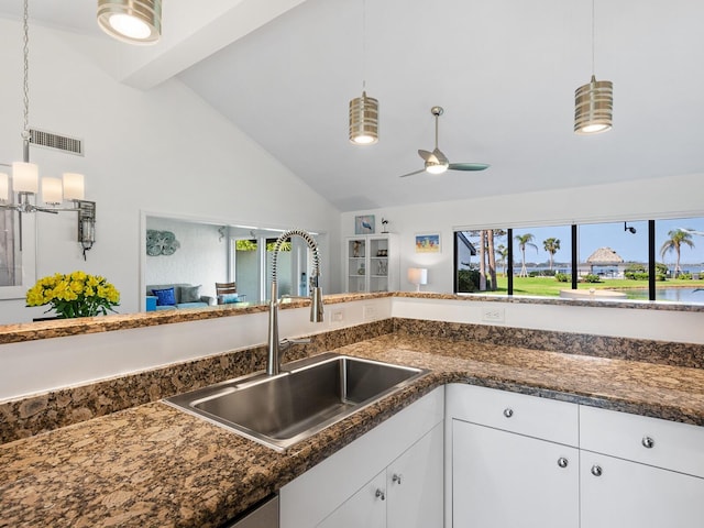 kitchen with ceiling fan, pendant lighting, beam ceiling, white cabinets, and sink