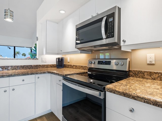 kitchen featuring stainless steel appliances, decorative light fixtures, white cabinetry, lofted ceiling, and hardwood / wood-style flooring