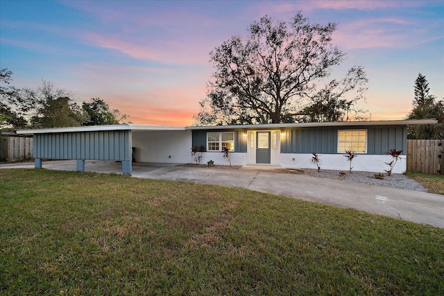 ranch-style home with a lawn and a carport