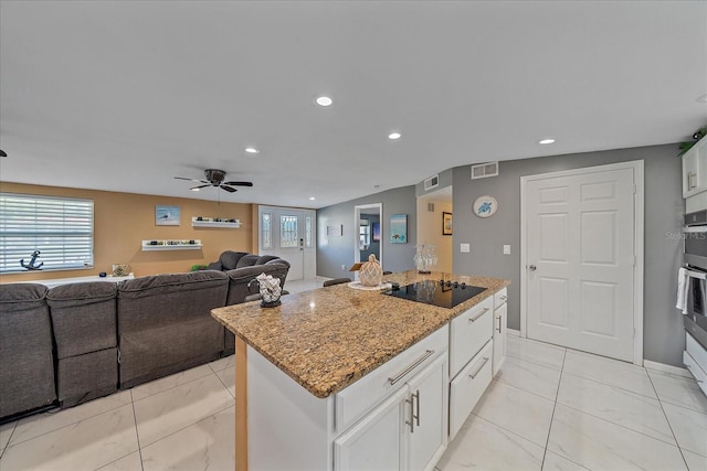 kitchen featuring a center island, white cabinets, ceiling fan, light stone countertops, and black electric cooktop