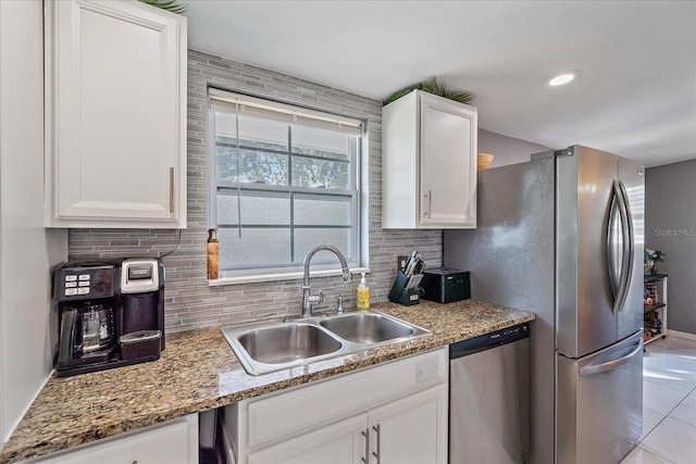 kitchen with light stone countertops, white cabinetry, sink, and appliances with stainless steel finishes