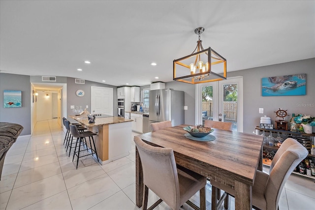 dining space with french doors and an inviting chandelier