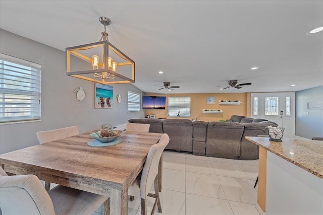 dining room with ceiling fan with notable chandelier