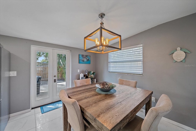 tiled dining room with a chandelier and french doors