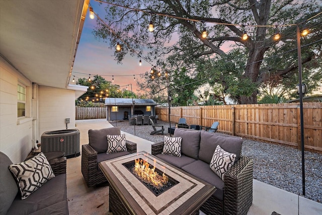 patio terrace at dusk with central air condition unit and an outdoor living space with a fire pit