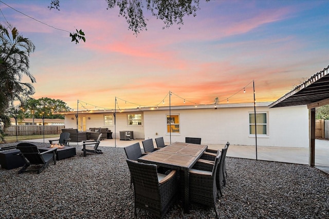 patio terrace at dusk with central AC unit and an outdoor living space with a fire pit