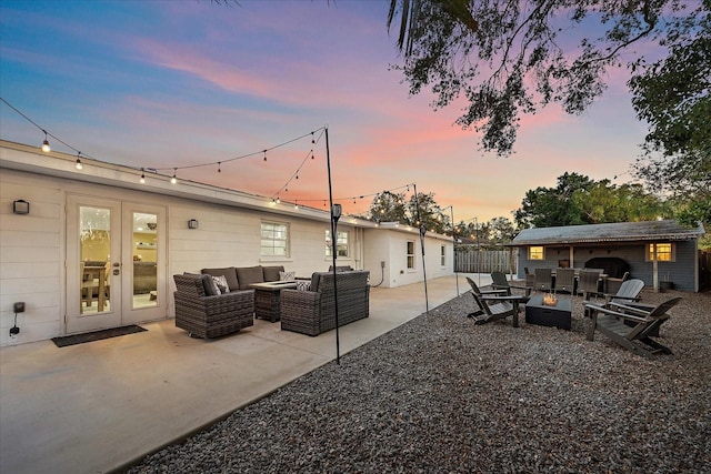 patio terrace at dusk featuring an outdoor structure and an outdoor hangout area