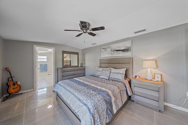 tiled bedroom with connected bathroom, ceiling fan, and vaulted ceiling