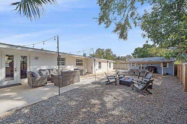 view of yard with central AC, an outbuilding, a patio, and an outdoor living space with a fire pit