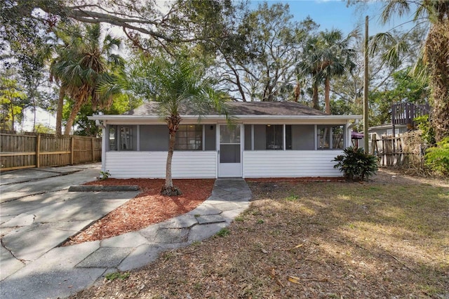 view of front of house with a sunroom and fence