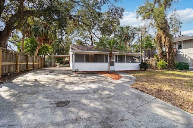 ranch-style house featuring a carport and a sunroom