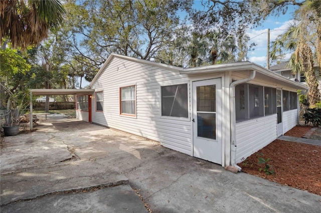 view of side of home featuring a carport and a sunroom