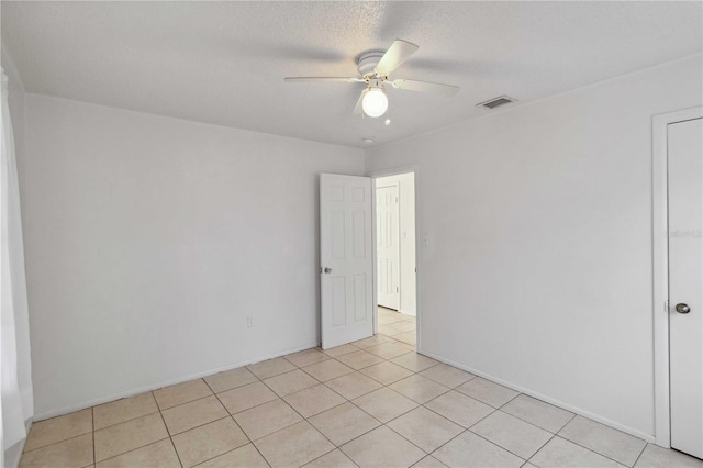 tiled spare room with ceiling fan and a textured ceiling