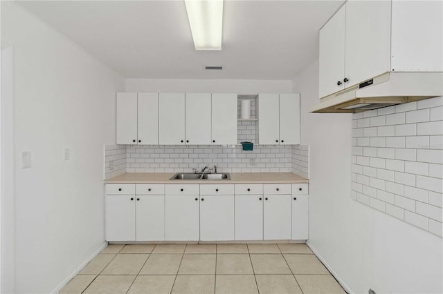 kitchen featuring white cabinetry, light tile patterned flooring, sink, and decorative backsplash