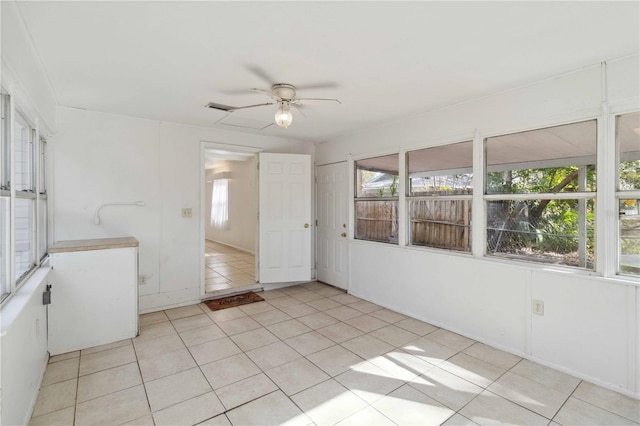 unfurnished sunroom with ceiling fan