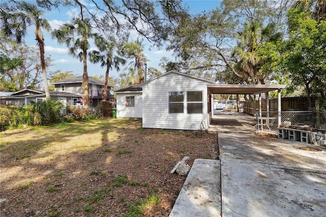 back of property featuring a carport and a lawn