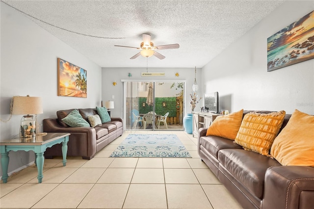 living room with a textured ceiling, ceiling fan, and light tile patterned floors