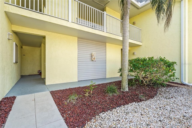 view of exterior entry with a balcony