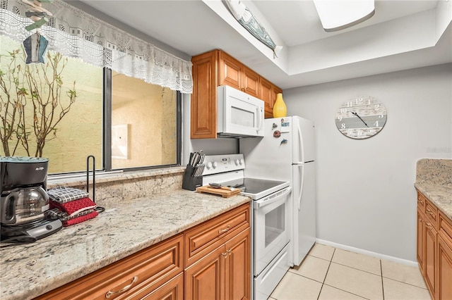 kitchen with white appliances, light tile patterned flooring, and light stone counters