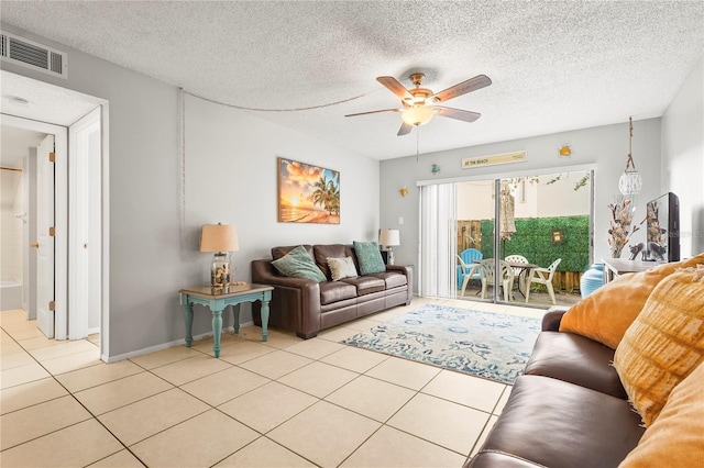 tiled living room featuring a textured ceiling and ceiling fan