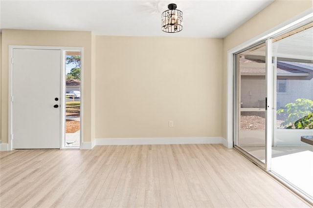 interior space featuring light wood-type flooring and an inviting chandelier