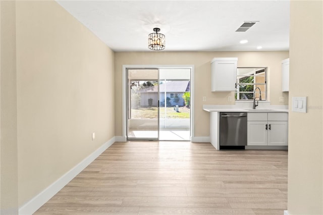 kitchen featuring sink, stainless steel dishwasher, pendant lighting, white cabinets, and light wood-type flooring