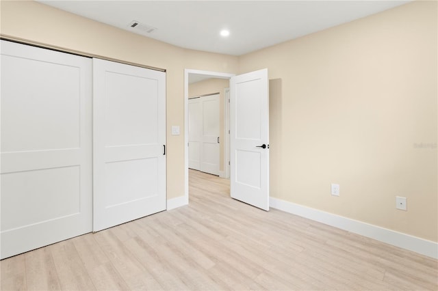 unfurnished bedroom featuring light hardwood / wood-style floors and a closet