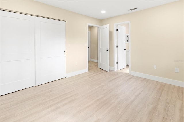 unfurnished bedroom featuring light hardwood / wood-style floors and a closet