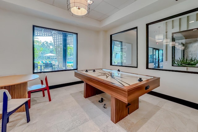 game room with a raised ceiling