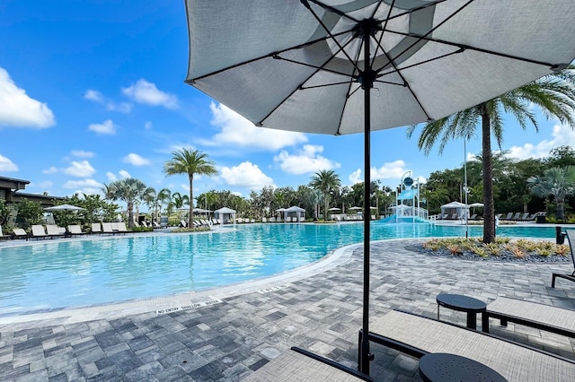 view of pool featuring a water slide and a patio area