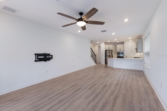 unfurnished living room with ceiling fan and light hardwood / wood-style flooring