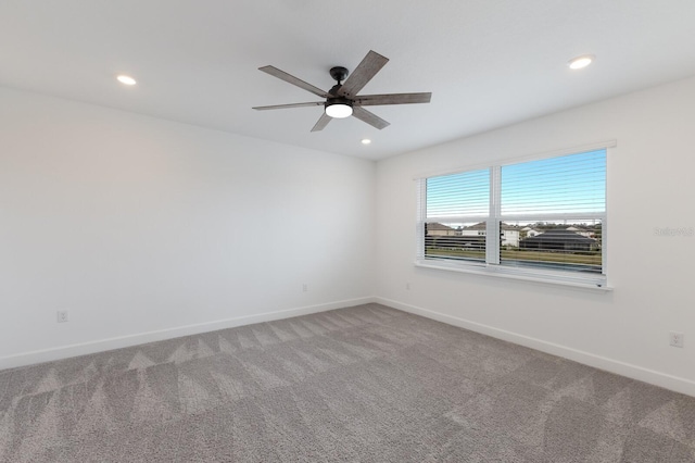 carpeted spare room featuring ceiling fan