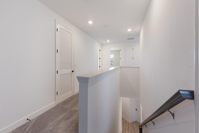 hallway with light colored carpet