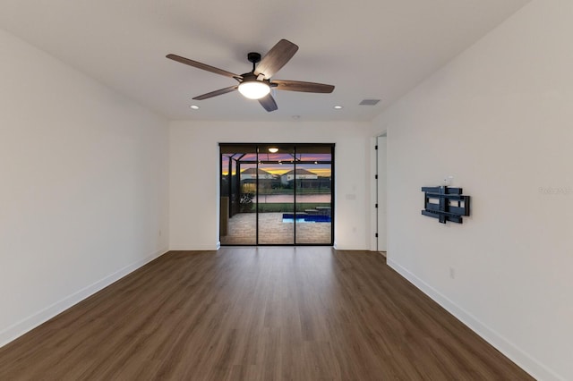 spare room with dark wood-type flooring and ceiling fan