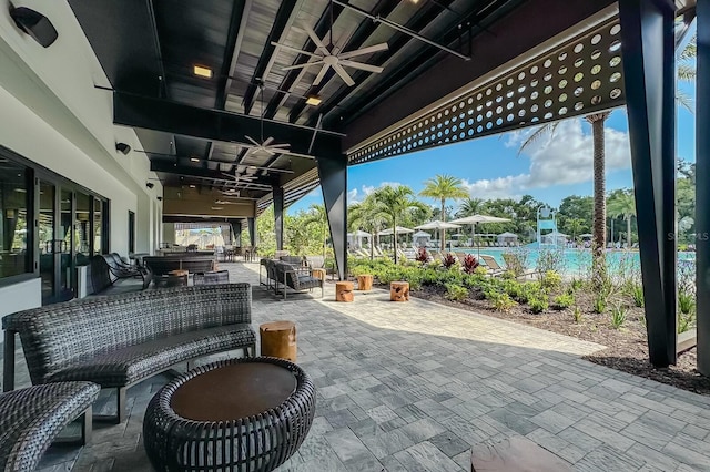 view of patio with exterior kitchen, outdoor lounge area, a pool, and ceiling fan