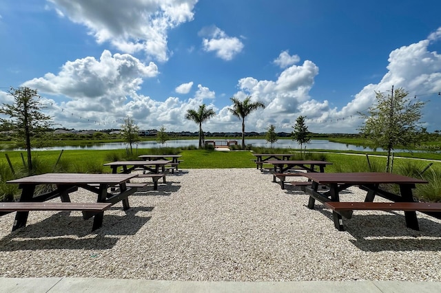 view of home's community with a water view and a yard