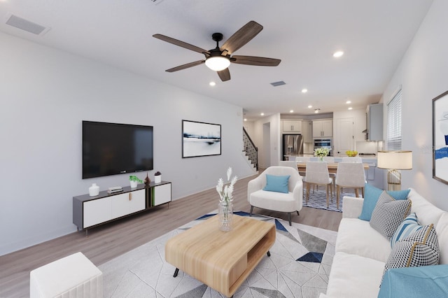 living room with ceiling fan and light wood-type flooring