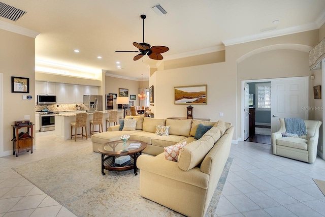 living room with ceiling fan, ornamental molding, and light tile patterned floors