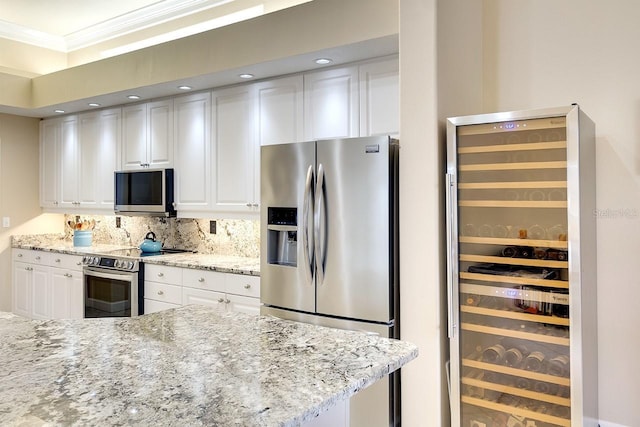 kitchen with white cabinetry, light stone counters, wine cooler, and appliances with stainless steel finishes