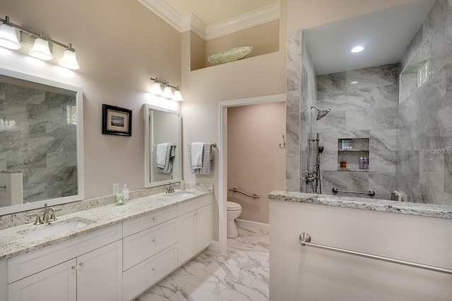 bathroom featuring vanity, toilet, ornamental molding, and tiled shower