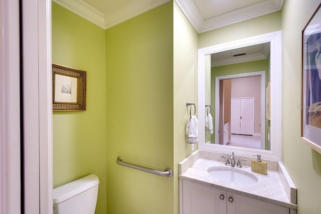 bathroom with toilet, vanity, and ornamental molding