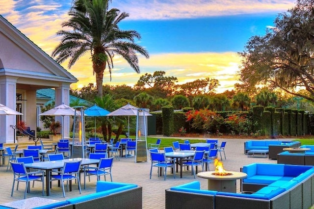 patio terrace at dusk with an outdoor living space with a fire pit