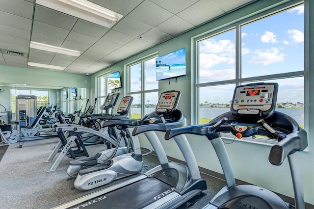 gym featuring a paneled ceiling, baseboards, and visible vents