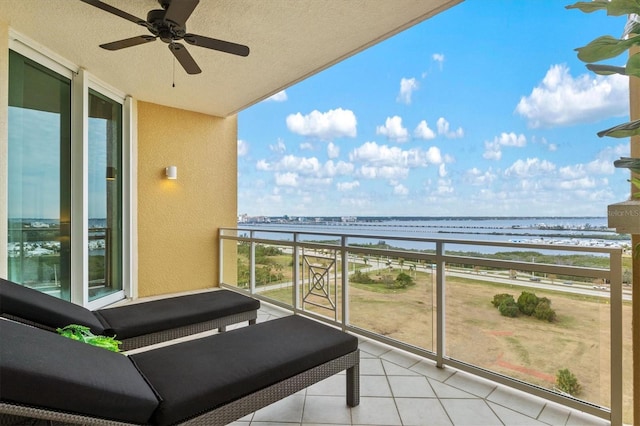 balcony featuring a ceiling fan and a water view