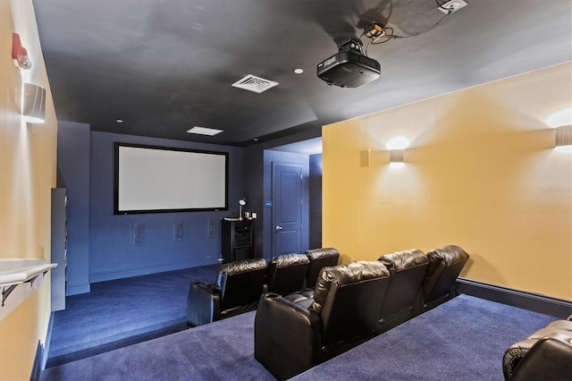 cinema room with carpet flooring, visible vents, and baseboards